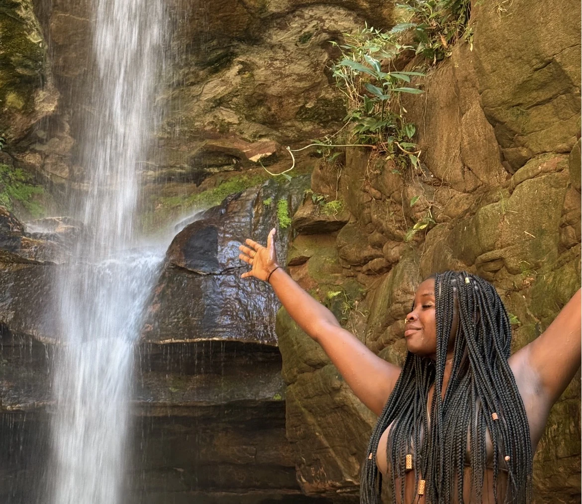 Camryn Imani celebrating wellness and flow near a waterfall
